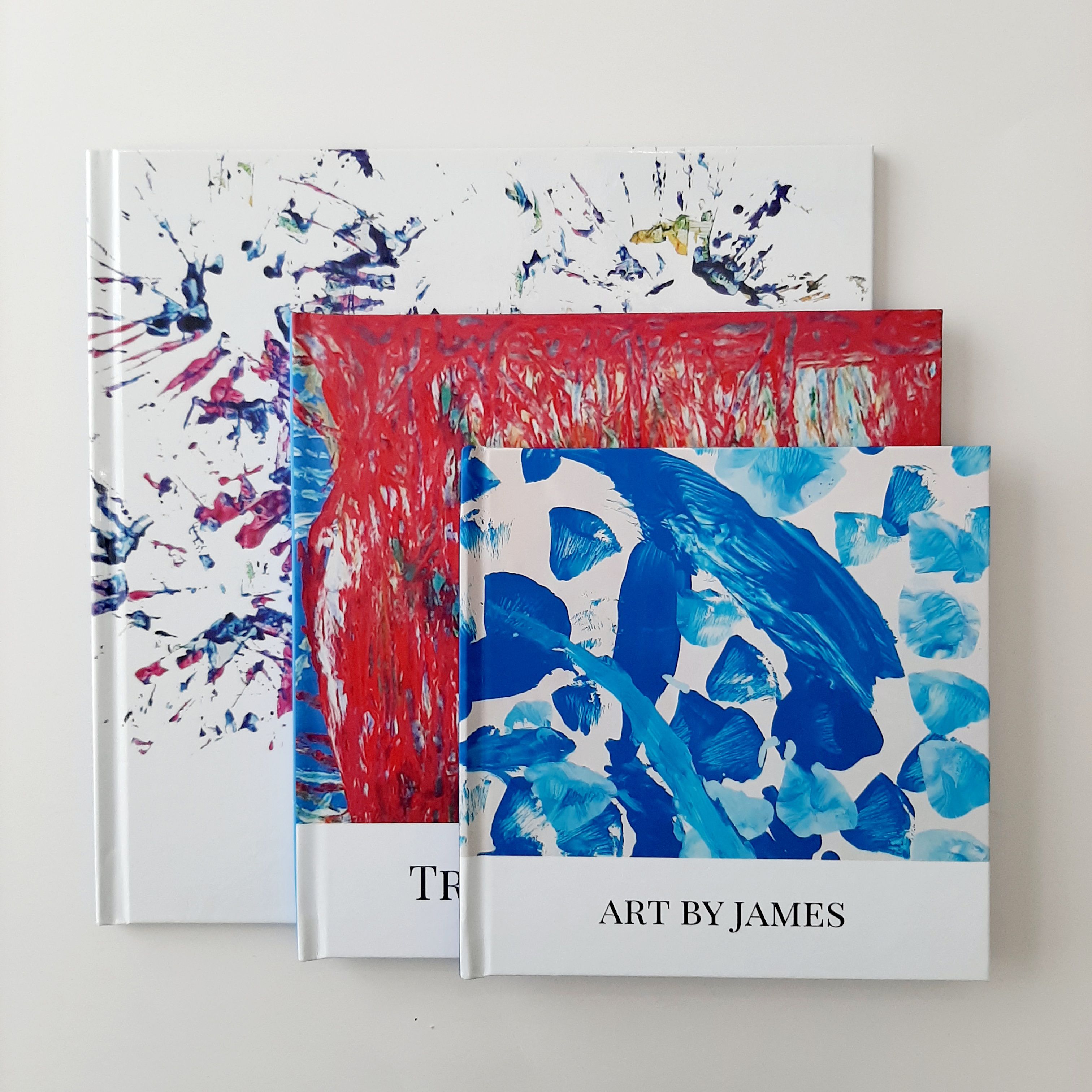 Three keepsake art books with children's artwork on the covers